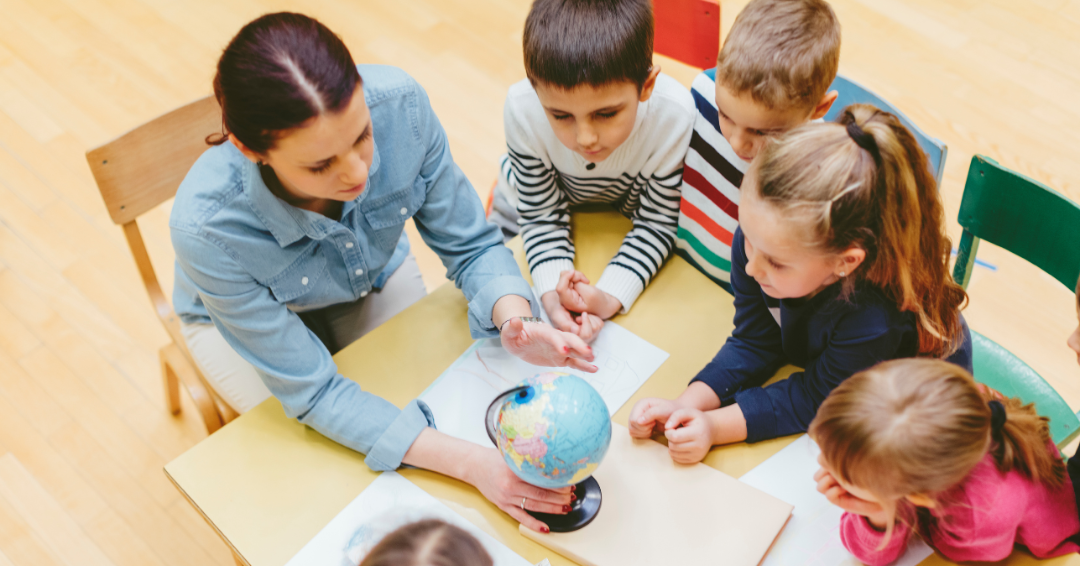 nauczycielka pokazuje dzieciom globus